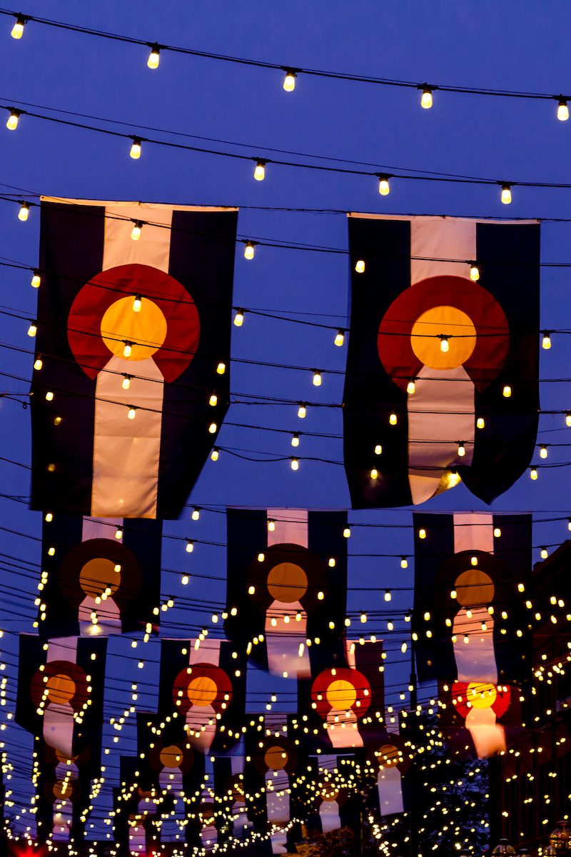 Business Owner Investment Services offered by Full Circle Financial of Colorado - Colorado Flags hanging with small lights on Historic Larimer Square in Denver Colorado
